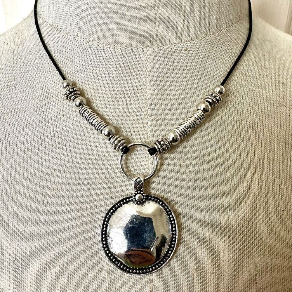 Silver tone pendant necklace on black cord